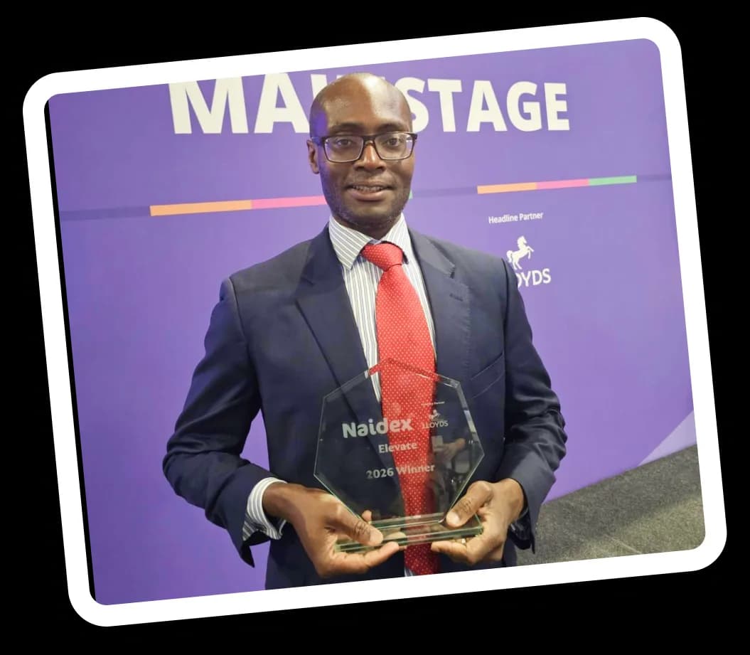 Alex holds the Naidex Elevate 2026 winner's trophy on the main stage